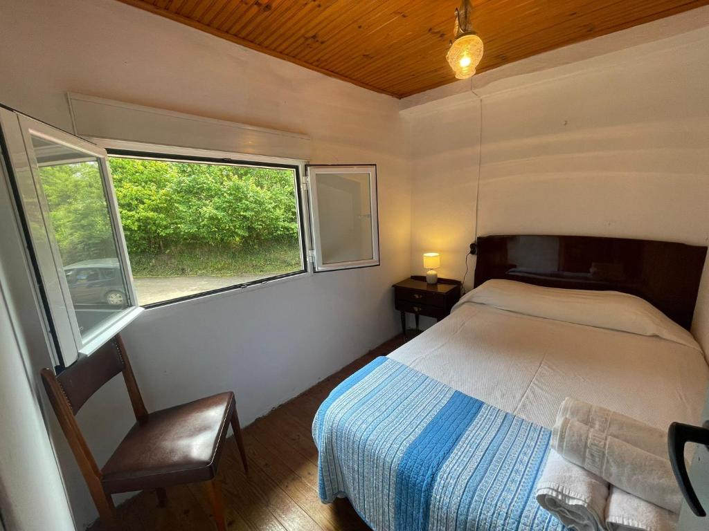 a small bedroom with a bed and a window at La Casina de Castiello in Castiello