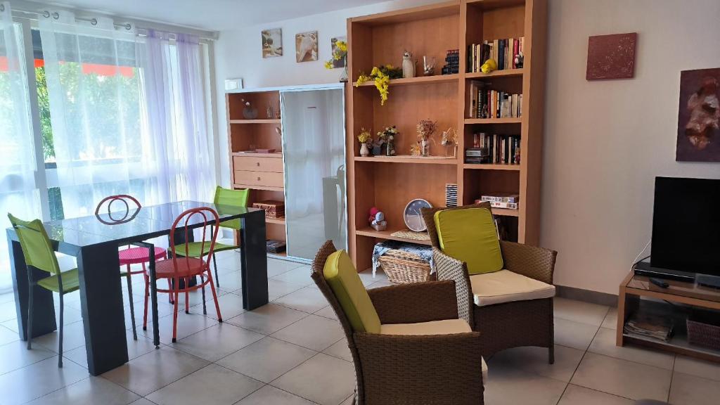 un salon avec une table et des chaises de salle à manger dans l'établissement Grand appartement familial a 2 pas du port de St Cyprien, à Saint Cyprien Plage