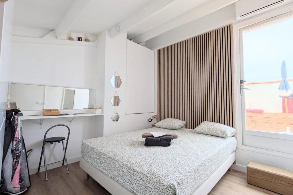 une chambre avec un lit, un bureau et une fenêtre dans l'établissement Naturiste Cap d'Agde Port Soleil 146, au Cap d'Agde