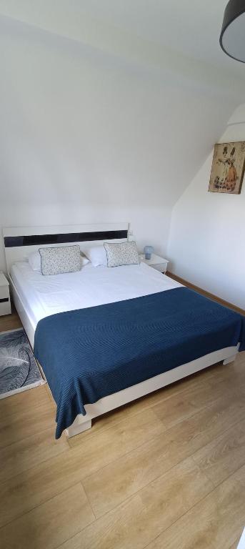 a bedroom with a large bed with a blue blanket at AP Apartment's Rodzinny in Wałbrzych