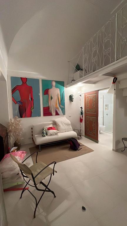 a living room with a couch and paintings on the walls at Casa Stella Marina in Ponza