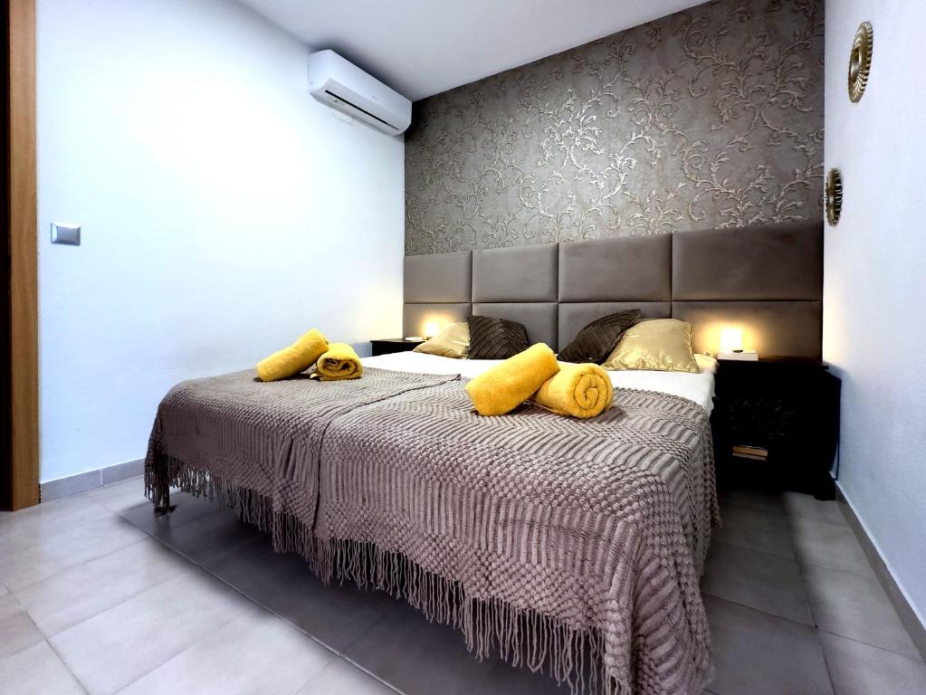 a bedroom with a large bed with yellow pillows on it at Apartament z widokiem na morze 250 m od plaży in Torrevieja