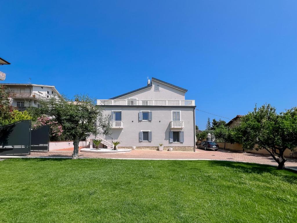 a large white house with a green lawn at Al Giardino del Pepe in Lanciano