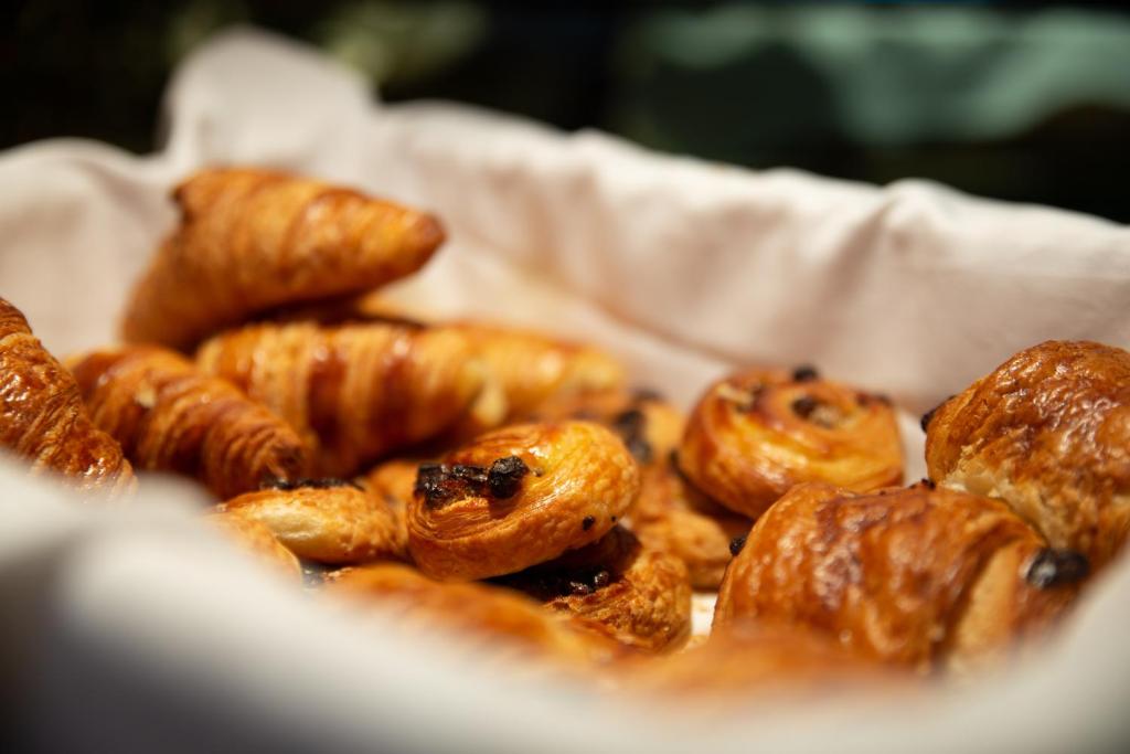 a pile of pastries in a white basket at Zenitude Hôtel-Résidences Le Havre Les Docks in Le Havre