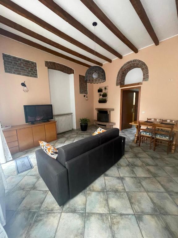 a living room with a black couch and a table at Camino Apartment in Rho