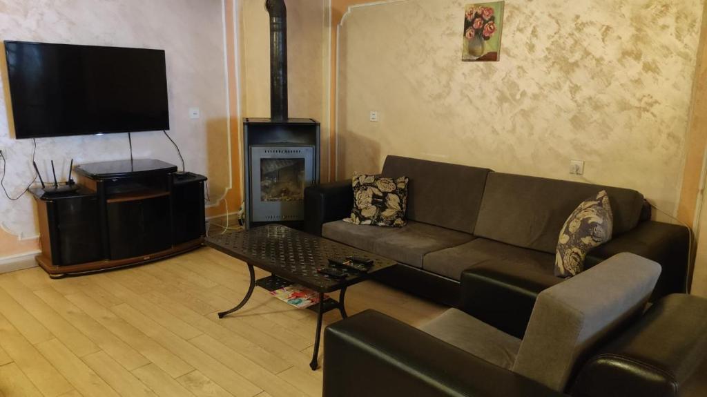 un soggiorno con divano e camino di Ushba House a Mestia