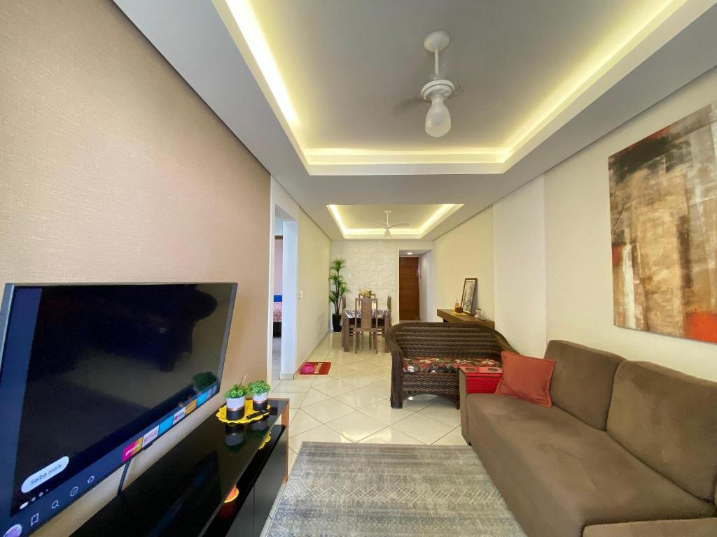 ein Wohnzimmer mit einem großen Flachbildfernseher in der Unterkunft Conforto na Praia – Apto 2 Qtos Guilhermina in Praia Grande