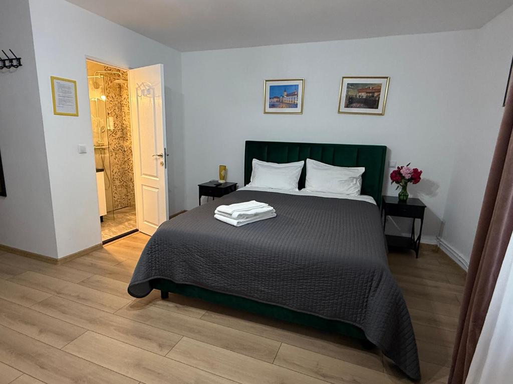 een slaapkamer met een bed met twee handdoeken erop bij Candy-Bombon Sibiu in Sibiu