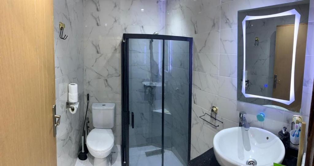 um banheiro com chuveiro, vaso sanitário e pia em Hay el mohamadi agadir em Agadir