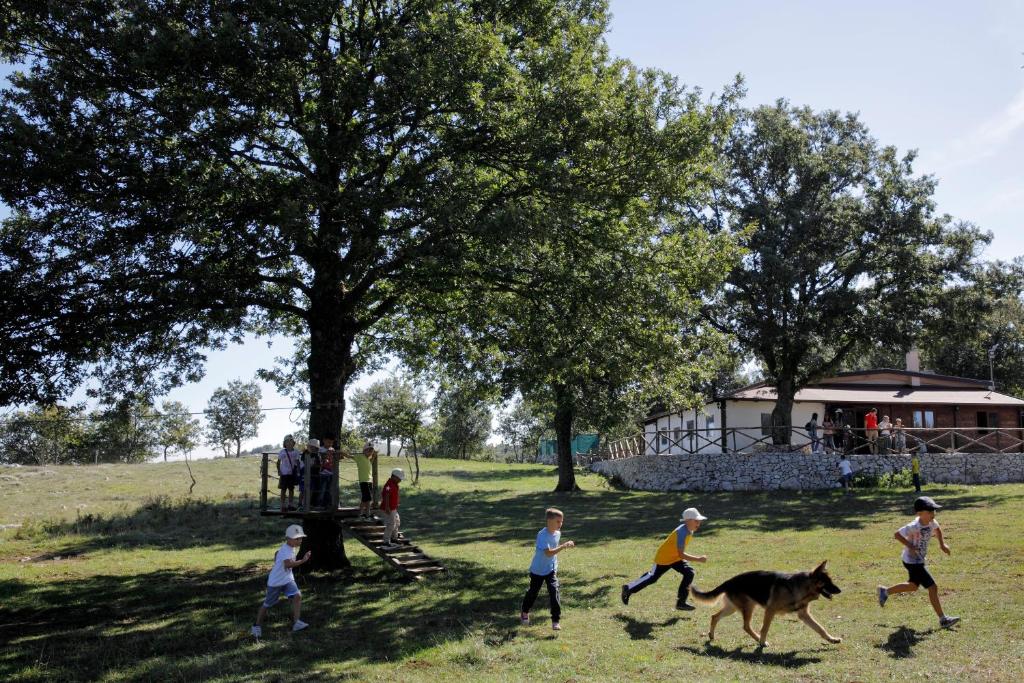 a group of children playing with a horse in a field at Le Chiancate in San Giovanni Rotondo