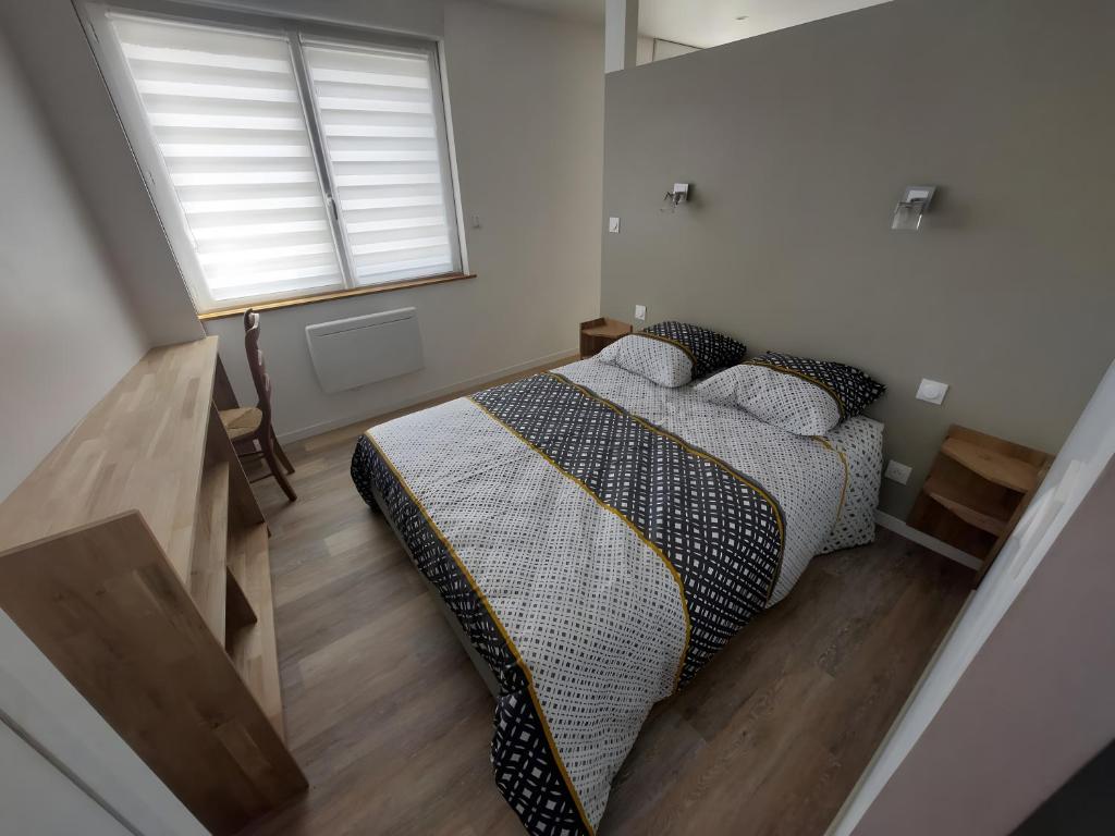 une chambre avec un lit avec des oreillers et une fenêtre dans l'établissement Appartement Rdc, Morgat Plage, à Crozon