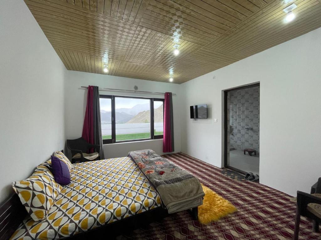 a bedroom with a bed and a large window at Roof Top Homestay in Leh
