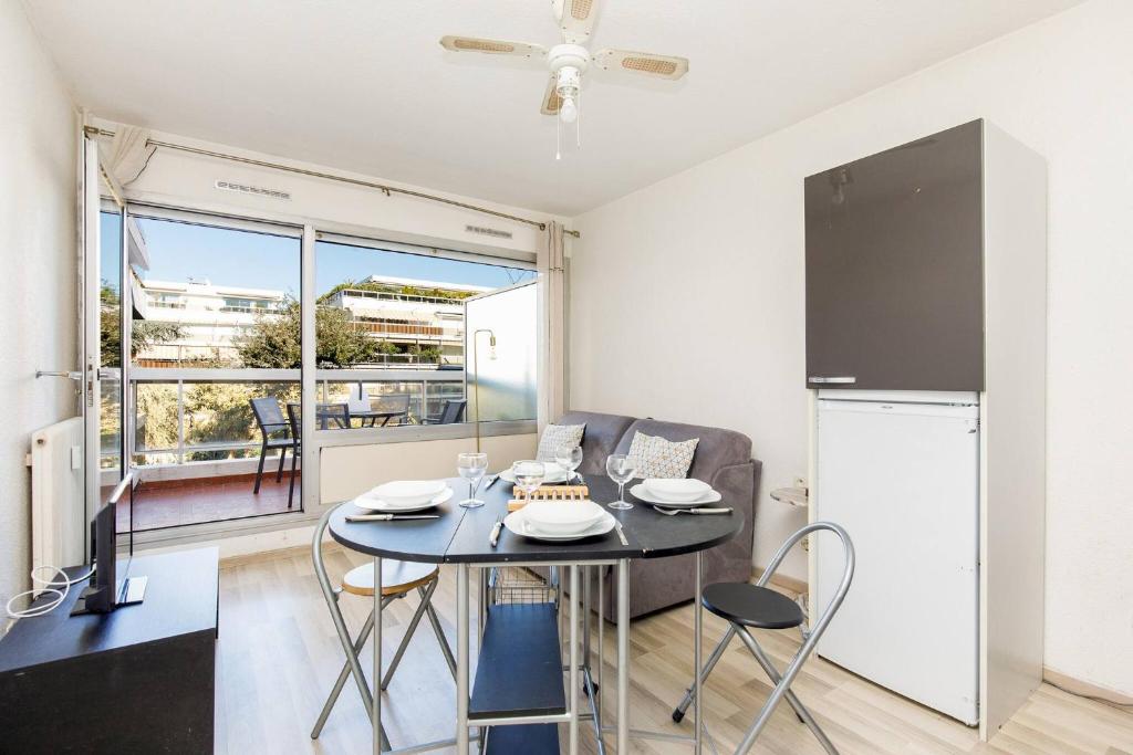 une cuisine et une salle à manger avec une table et des chaises dans l'établissement COCO - Beau 2 P climatisé wifi terrasse piscine, à Antibes