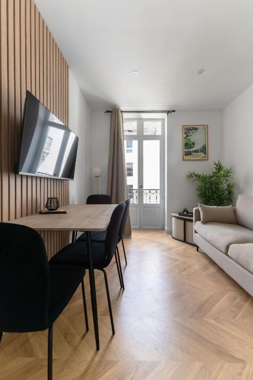 a living room with a table and a couch at Chez Virginie Triangle d'Or in Vichy