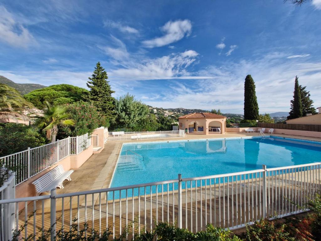 une grande piscine entourée d'une clôture blanche. dans l'établissement Cavalaire sur mer maison de vacances, à Cavalaire-sur-Mer