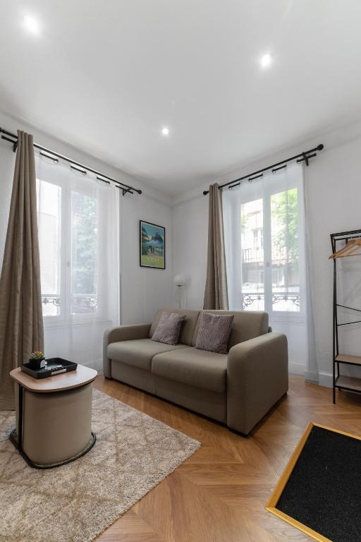 a living room with a couch and a table at Chez Juliette Triangle d'Or - Rez de Chaussée in Vichy