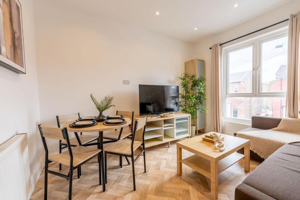a living room with a table and a couch at Luxury 1-bed Near MCR Hospital & City Centre in Manchester