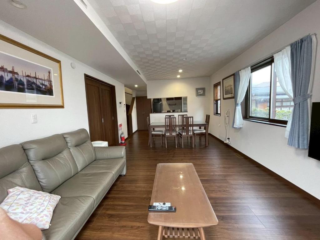 a living room with a couch and a coffee table at 河口湖駅徒歩10分 ベルショッピングセンター徒歩6分 大型4ldk屋根裏付き 全室空調 in Wada