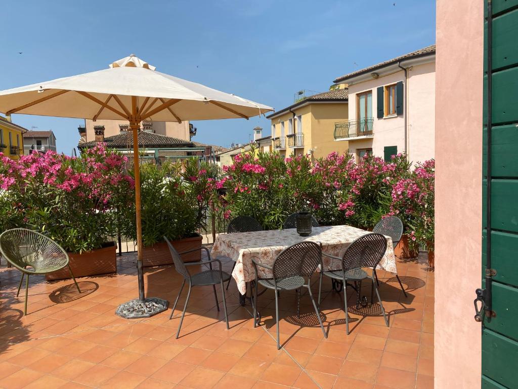 a table and chairs with an umbrella on a patio at La Casa Di Mimi in Bardolino