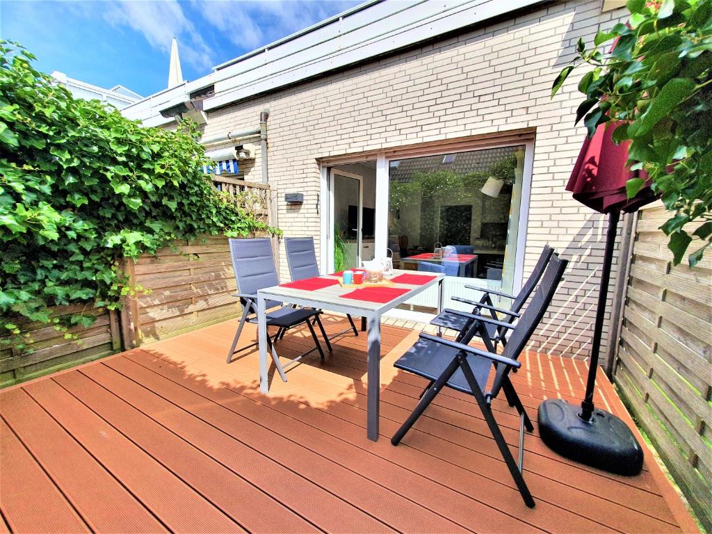 a patio with a table and chairs on a deck at Strandliebe in Langeoog