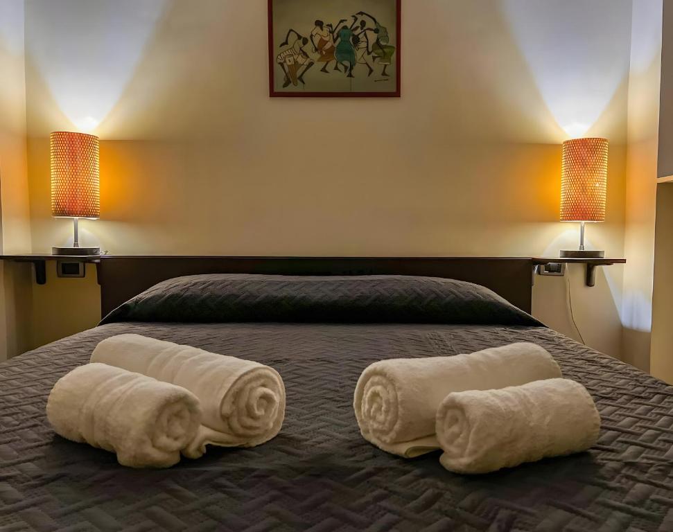 1 dormitorio con 2 toallas en una cama con 2 lámparas en A Due Passi Dal Mare - Pegli, en Génova