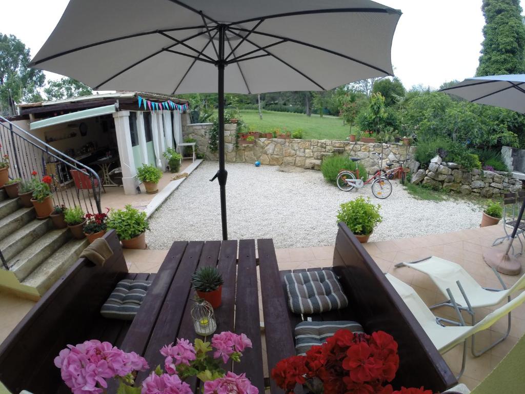 a wooden table with an umbrella on a patio at Apartment Alba in Funtana