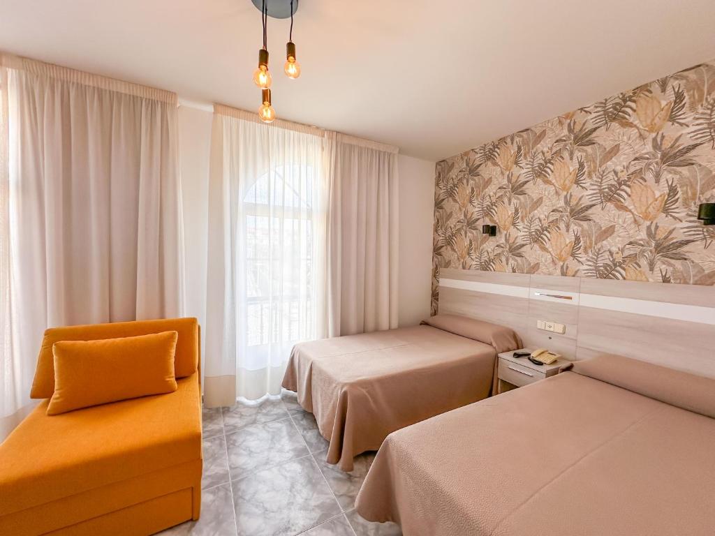 サンシェンショにあるHotel Florida Marのベッド2台、椅子、窓が備わる客室です。