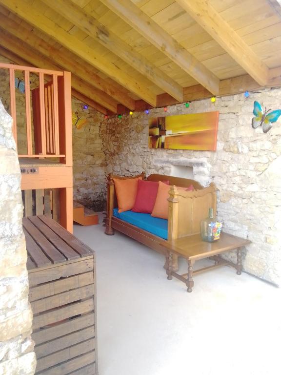 Cette chambre comprend un canapé, une table et un banc. dans l'établissement La Loge de Fleur, à Anglars-Saint-Félix