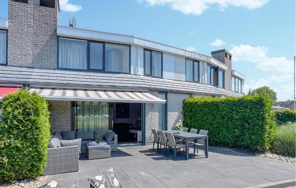 ein Haus mit einer Terrasse mit Tisch und Stühlen in der Unterkunft Three Bedroom Awesome Home In Lemmer in Lemmer