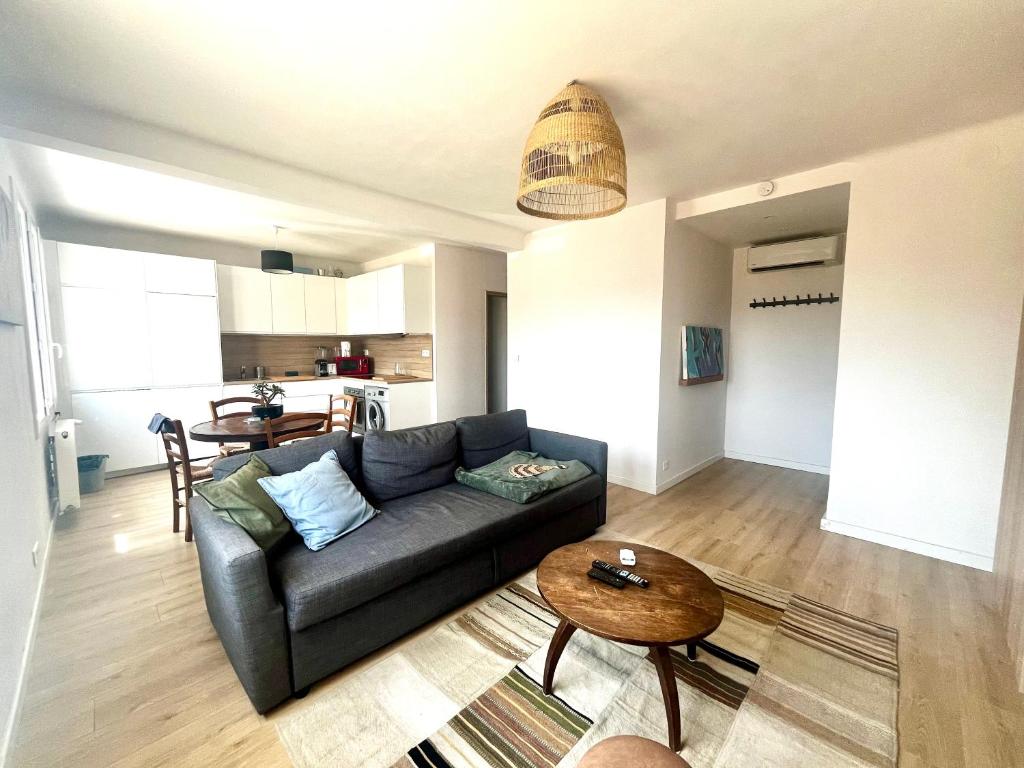 un salon avec un canapé et une table dans l'établissement Aix centre - Appartement Cosy avec Terrasse et Clim, à Aix-en-Provence