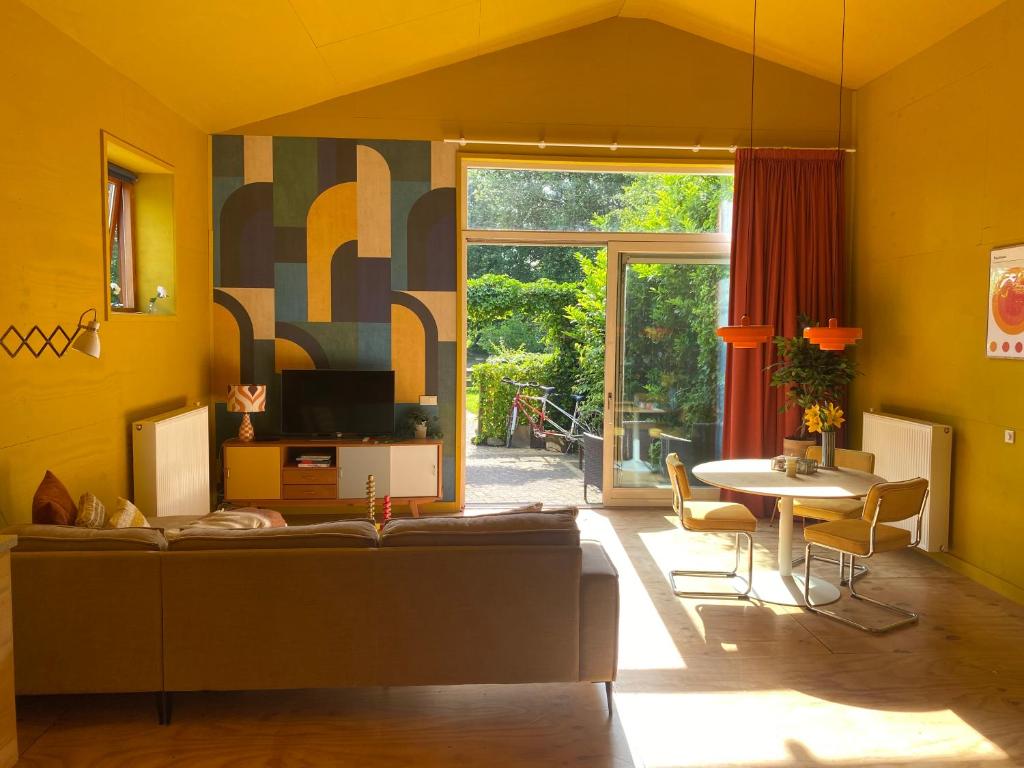 a living room with a couch and a table at Assen-Groningen-Saunacabine in Vries