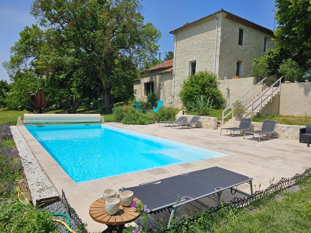 a swimming pool in front of a house at La Bohème in Condom