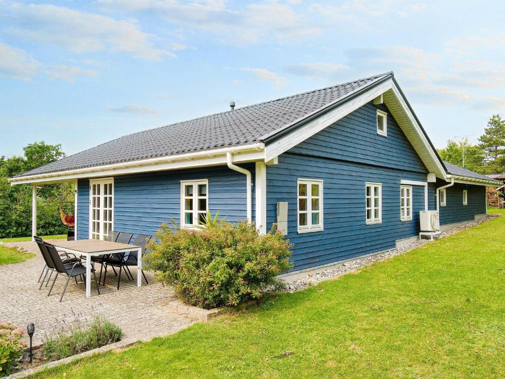 a blue house with a picnic table in front of it at 9 person holiday home in Jægerspris-By Traum in Jægerspris
