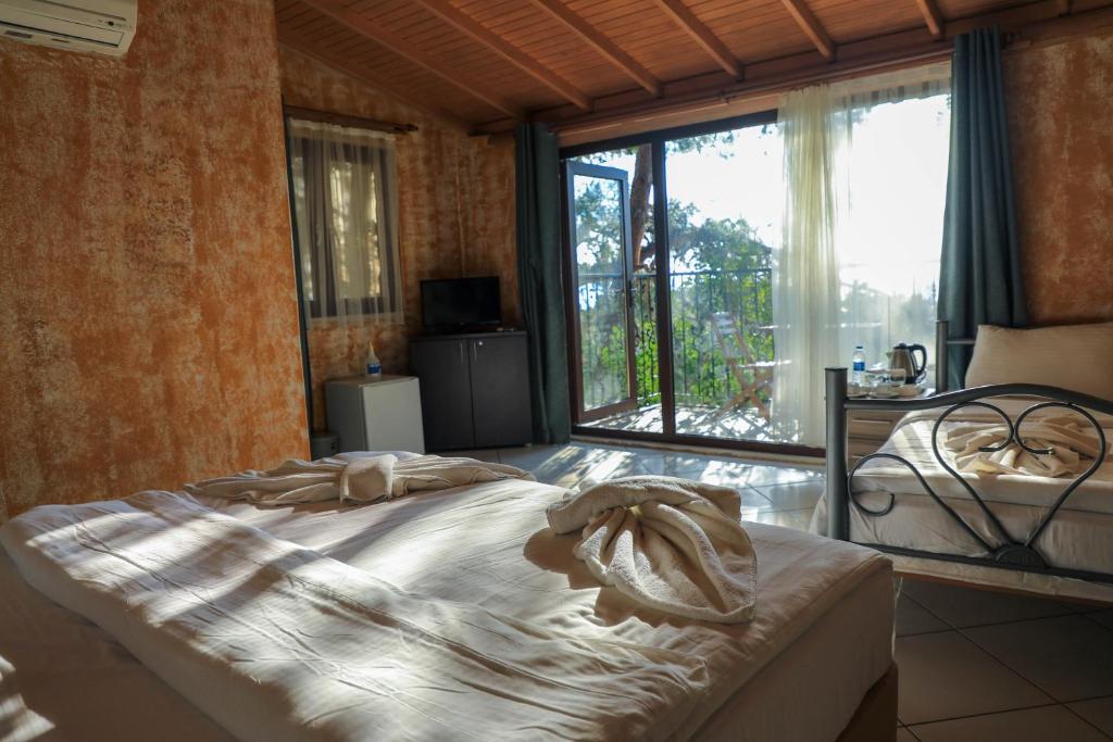 a bedroom with a large bed and a large window at Symbola Oludeniz Beach Hotel in Oludeniz