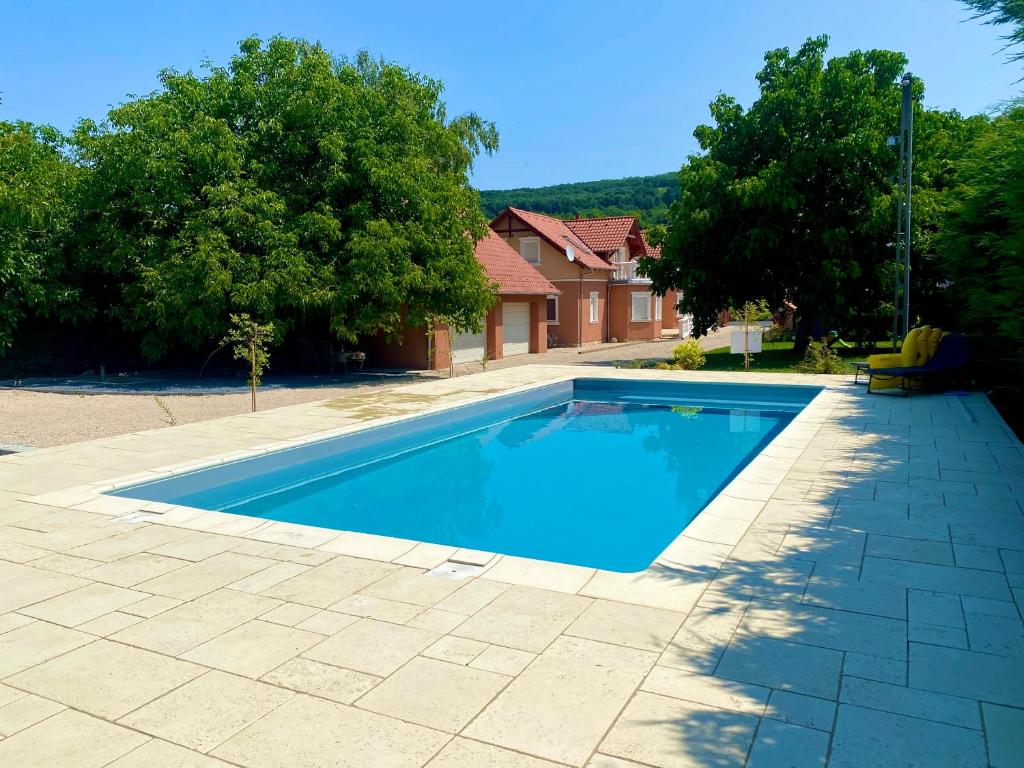 - une piscine dans une cour avec des arbres et une maison dans l'établissement Bikeaway Guesthouse, à Kereki