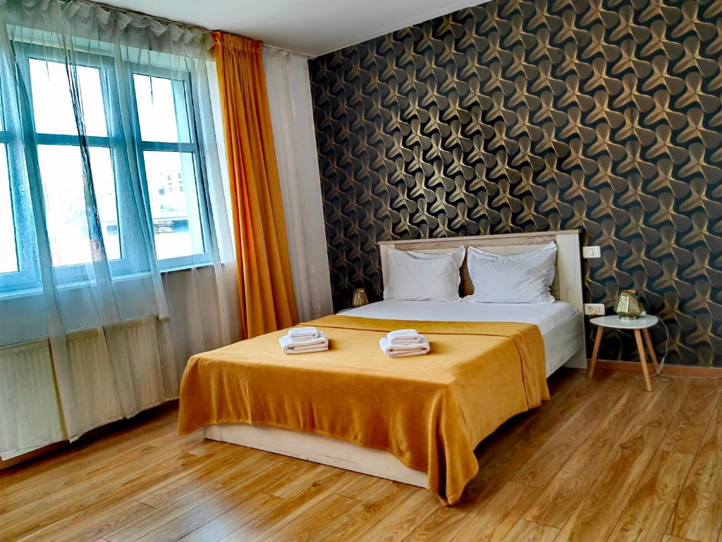 a bedroom with a bed with two towels on it at CoZy Apartments in Timişoara