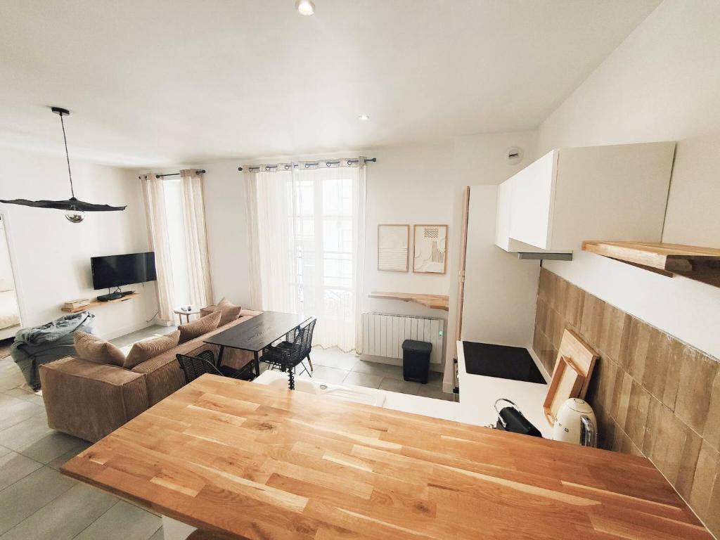a living room with a table and a couch at Appartement Le Cœur de Nîmes Secteur Arènes Parking Offert ! in Nîmes