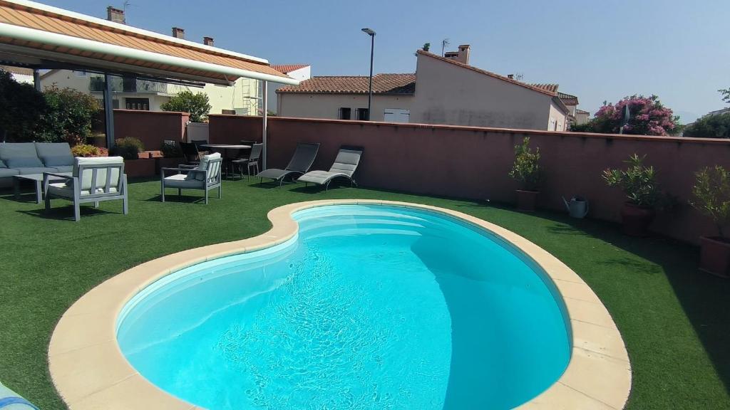 une grande piscine bleue dans une cour dans l'établissement St Cyprien plage grande maison avec piscine, à Saint Cyprien Plage