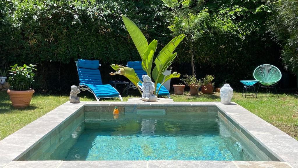une piscine dans une cour avec deux chaises et des meubles de piscine dans l'établissement Le Mas de Fabregas - 500 m de la plage, à La Seyne-sur-Mer