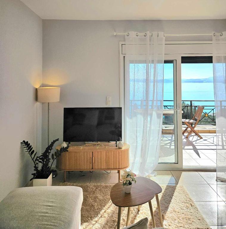 a living room with a large flat screen tv at Ionelia Seaview Apartment at Barbati in Barbati
