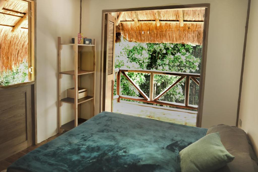 a bedroom with a bed and a large window at City Escape Casa Mariguana in Turbaco