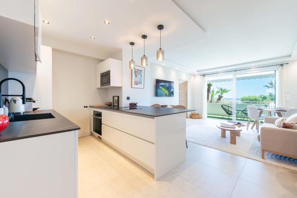 une cuisine et un salon avec un canapé et une table dans l'établissement Cannes Garden-Level 1-Br Apartment Sea View, à Cannes