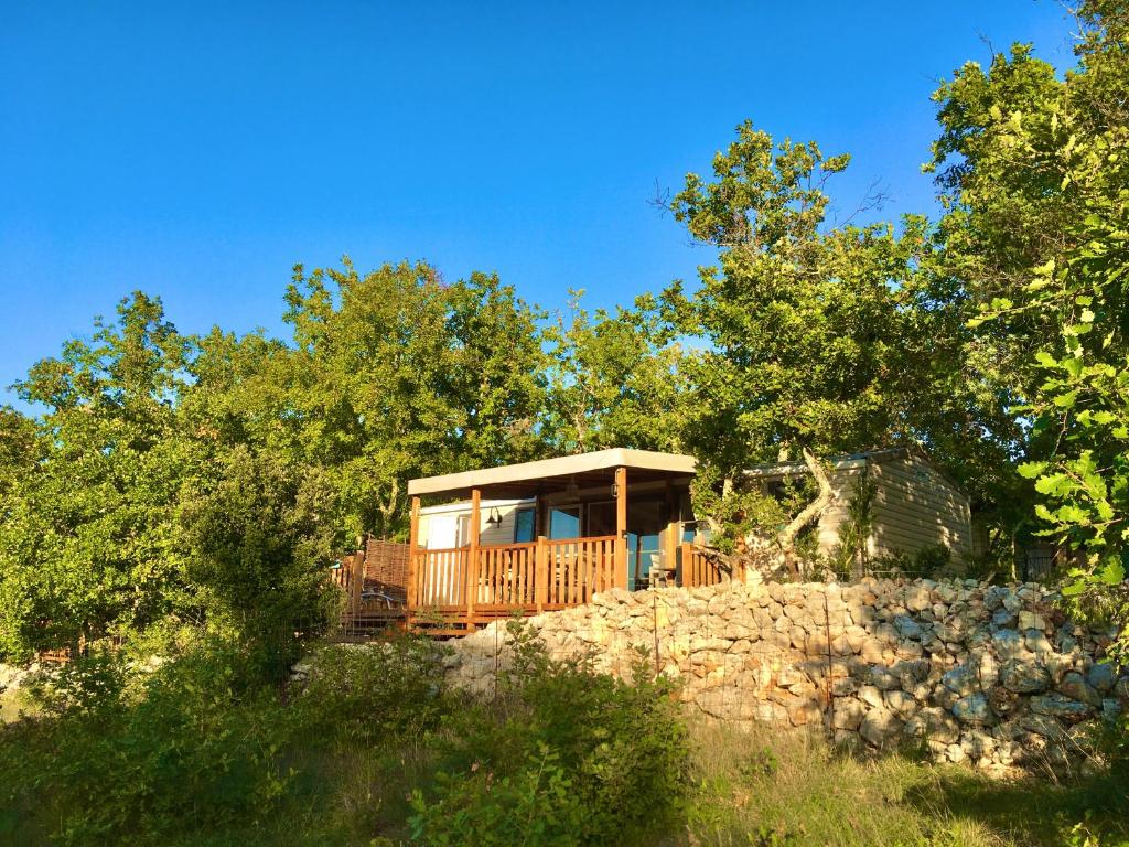 a cabin on a hill with trees in the background at Le Clos des Capitelles in Saint-Privat-de-Champclos