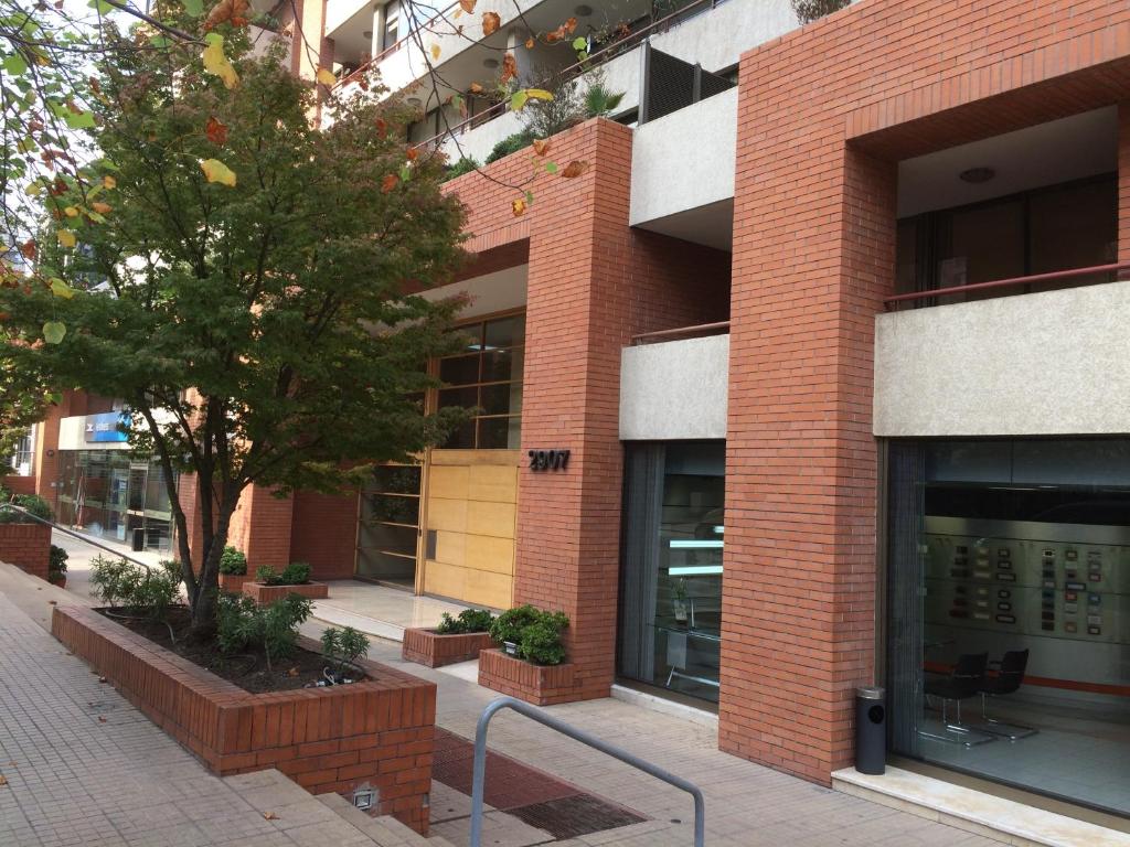 a brick building with a tree in front of it at Aconcagua Apartments in Santiago