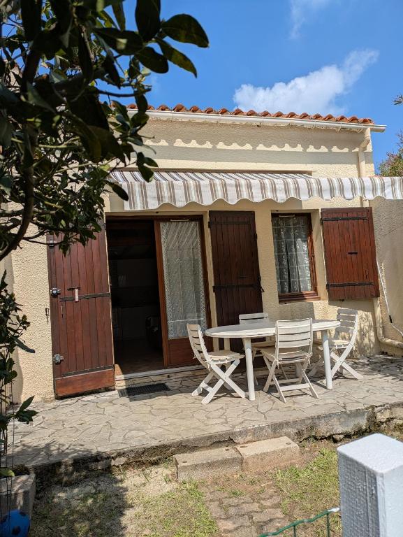 une table et des chaises devant une maison dans l'établissement Maison au bord de l'océan, à Vaux-sur-Mer