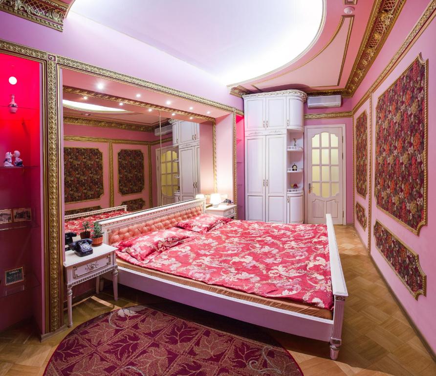 ein Schlafzimmer mit einem großen rosa Bett in einem Zimmer in der Unterkunft Odessa Apartments Cherkasets in Odessa