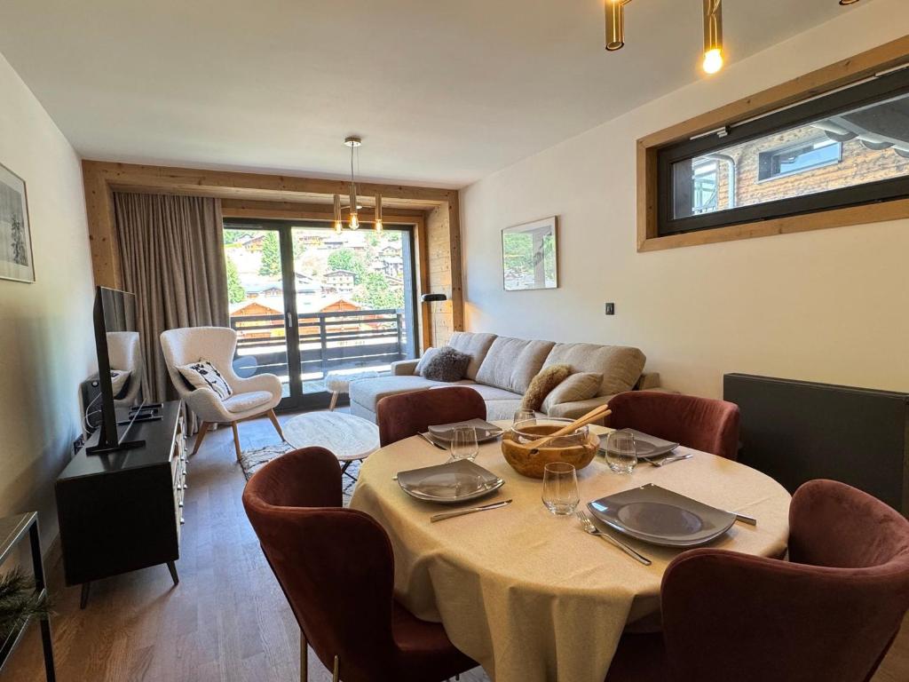 un salon avec une table et un canapé dans l'établissement Appartement lumineux au cœur des Gets avec balcon et parking - FR-1-623-222, aux Gets
