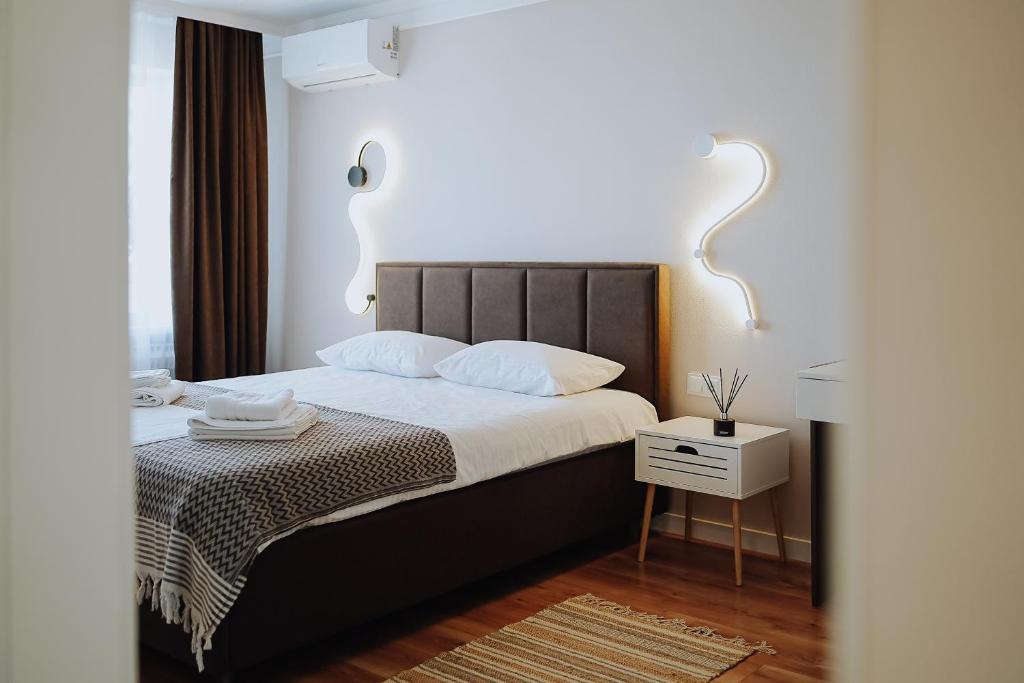 a bedroom with a bed with white sheets and a table at Central 1BR Near Piața Centrală & Bus Station in Chişinău