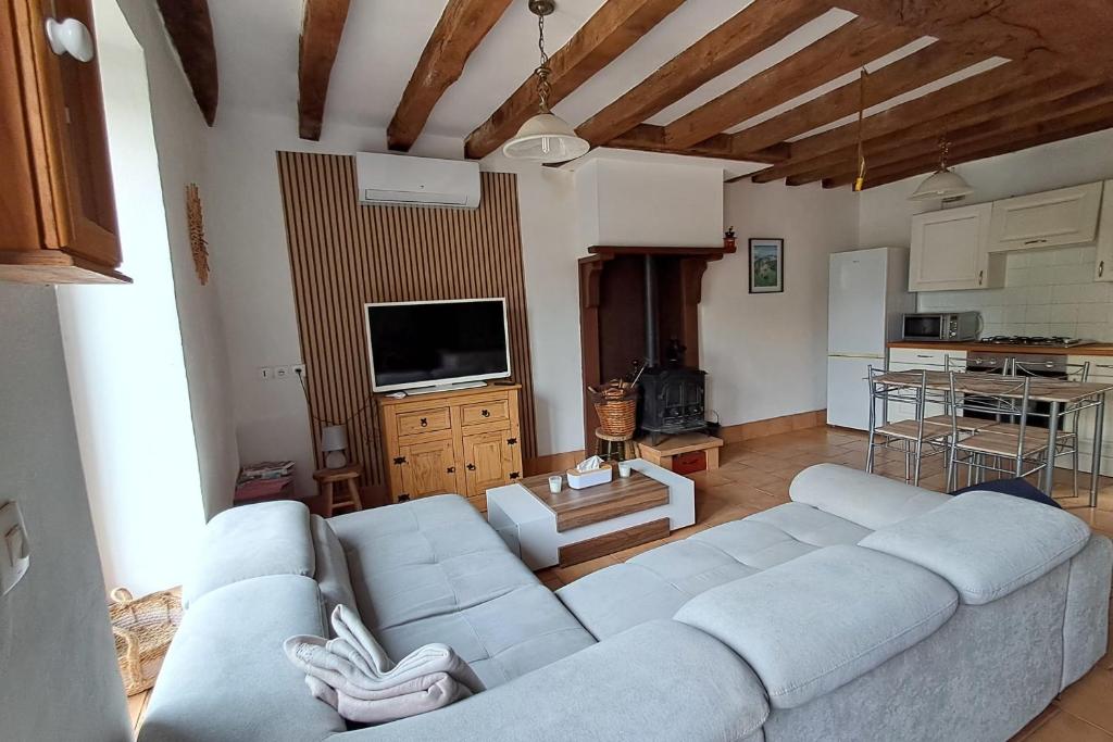 un salon avec un canapé et une télévision dans l'établissement Le Refuge de Montbroux, 