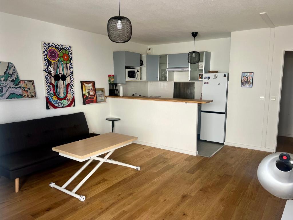 un salon avec une table et une cuisine dans l'établissement Chez Francesco, artist's apartment, à Montpellier